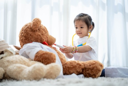 Anak perempuan bermain peran sebagai dokter.
