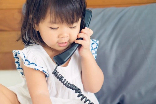 Anak sedang bermain telepon.